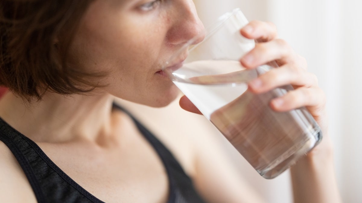 a woman drinking a glass of fresh water